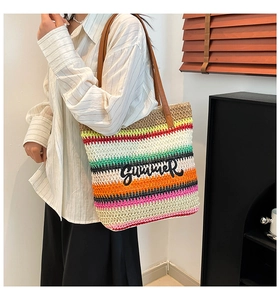 Close-up of colorful striped straw tote bag with Summer embroidery and leather straps