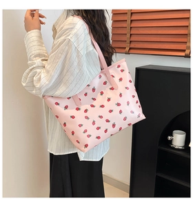 Sweet pink strawberry print tote bag shown on model in a modern home interior