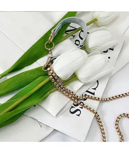Detail of light blue leather and gold chain shoulder strap for handbags with metal rings