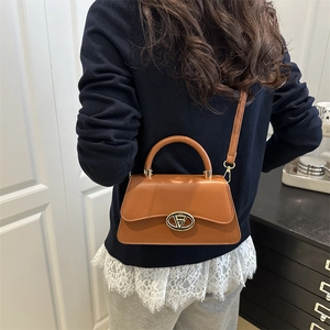 Classic brown leather tote bag with gold buckle shown in a stylish lifestyle setting