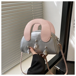 Detail of silver metallic handbag with pink strap and unique pearl charms decoration