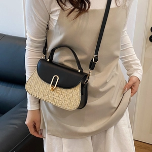 Sac bandoulière rétro en paille et cuir noir avec boucle dorée sur mannequin