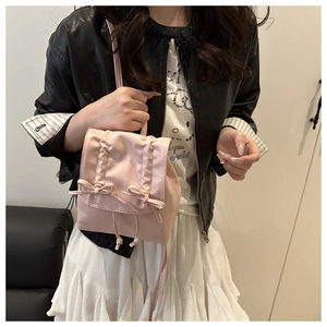 Detail of light pink ballet-style backpack with cute ribbon bows and drawstring closure