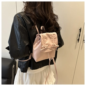 Détail du sac à dos plissé rose avec nœuds porté par un mannequin pour la taille