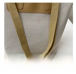 Detail view of reinforced shoulder strap stitching on a canvas tote bag in beige