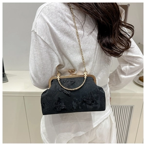 Detail of black lace handbag with 3D butterfly embroidery and gold chain strap