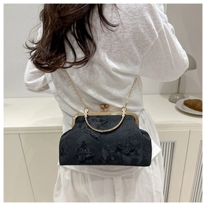 Detail of vintage black kiss-lock bag with 3D butterfly embroidery and gold chain strap