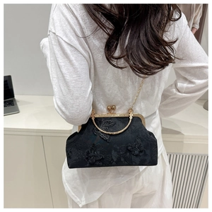 Detail of vintage black evening bag with 3D butterfly embroidery and gold chain strap