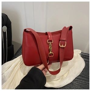 Détail du sac rouge avec fermoir métallique doré à piston de style rétro et cuir lisse
