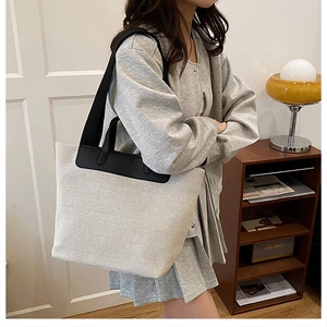 Lifestyle-Foto einer großen Canvas-Tote-Bag mit schwarzem Lederbesatz am Modell