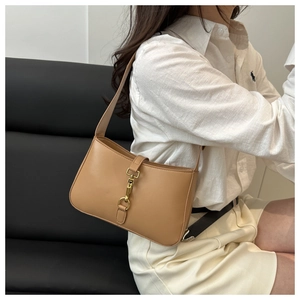 Vue latérale d'un sac sous les bras en cuir camel avec boucle à crochet dorée