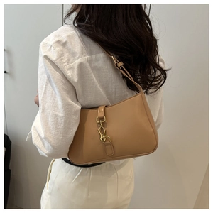 Close-up of khaki leather underarm bag with gold lobster clasp and smooth texture