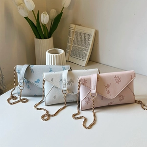 Three minimalist envelope chain bags with floral prints in soft pastel color tones