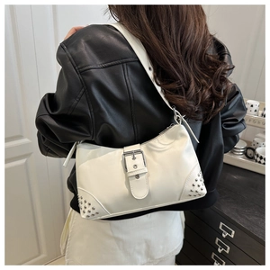 Détail d'un sac bandoulière en cuir blanc avec rivets argentés et boucle métal