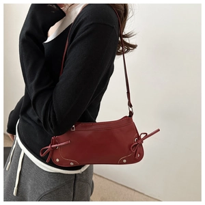 Vista dettagliata della borsa a spalla in pelle PU bordeaux con fiocchi decorativi laterali