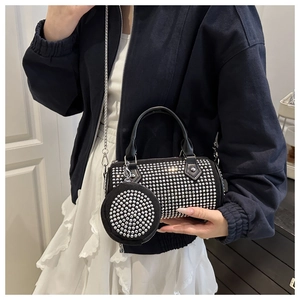 Detail of black cylinder bag with silver studs and round coin purse on a silver chain