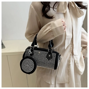 Détail du sac cylindre noir clouté avec mini porte-monnaie assorti et bandoulière chaîne