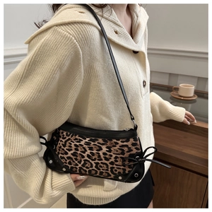 Close-up of leopard print shoulder bag featuring black bows and silver rivet details