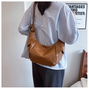Brown leather crescent shoulder bag with retro texture and unique knotted strap detail