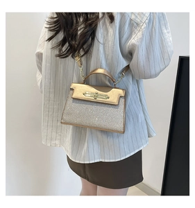 Detail of glitter champagne crossbody bag with metal twist lock on a model