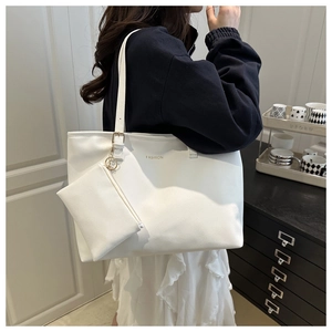 Detail view of white minimalist tote bag with FASHION lettering and small hanging pouch