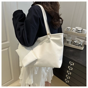 Detailed view of white leather tote bag with small purse and fashion lettering details