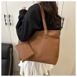 Detailed shot of a brown large-capacity tote bag with adjustable strap and fashion logo