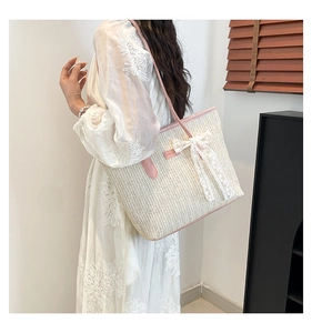Detailed view of the woven straw texture with pink leather trim and lace bow decoration