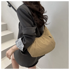 Sac hobo kaki en nylon plissé avec design en demi-lune porté par un mannequin