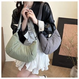 Détail des sacs hobo en nylon vert et gris avec design plissé et bandoulière réglable