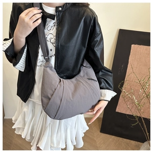 Détail latéral du grand sac croissant décontracté avec design plissé 3D et bandoulière