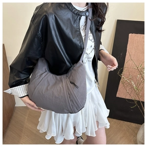 Vue détaillée d'un sac besace gris en nylon en forme de demi-lune avec bandoulière
