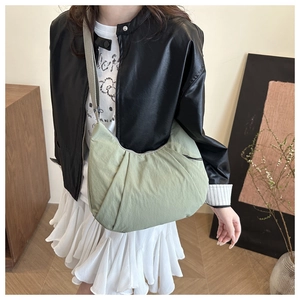 Vue détaillée du sac hobo vert clair en nylon plissé avec une large bandoulière souple