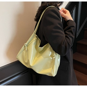 Dettaglio della borsa hobo verde chiaro lucida con design a tracolla annodata unica