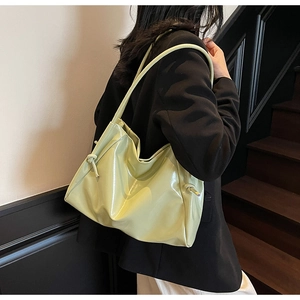 Dettaglio della borsa hobo verde avocado lucida con cinturino laterale annodato