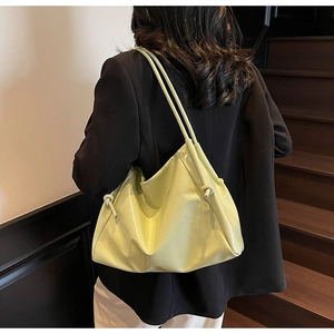 Dettaglio della borsa tote in pelle verniciata verde chiaro con finitura lucida e nodo