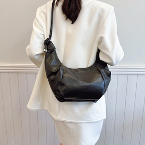 Chic black oversized hobo bag with knotted strap detail and sleek leather finish