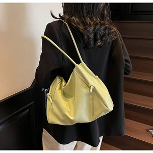 Vista dettagliata di un modello con una borsa tote in pelle PU lucida verde lime con lacci