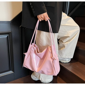 Dettaglio borsa tote in pelle verniciata rosa con pieghe morbide e lucide