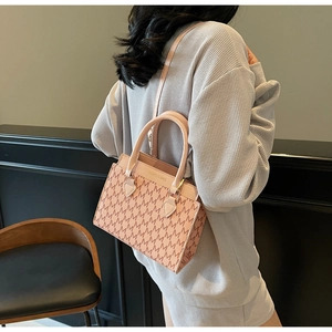 Détail d'un sac cabas à monogramme rose et marron avec finitions dorées élégantes
