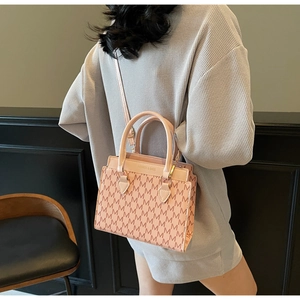 Detail view of pink beige tote bag with brown monogram pattern and fashion typography