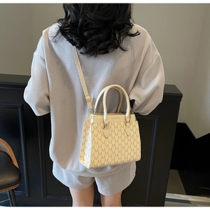 Détail du sac cabas crème avec imprimé monogramme et bandoulière réglable