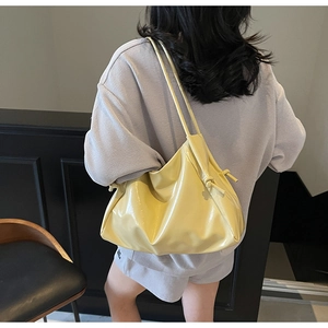 Dettaglio della borsa hobo giallo limone lucido con design unico del manico a nodo