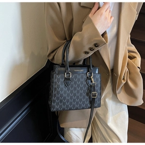 Détail du sac bandoulière noir à carreaux porté avec un blazer beige chic et élégant