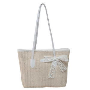 Contrast straw tote bag with white lace bow and leather handles for summer 2025 style