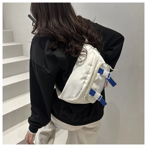 Détail du sac bandoulière blanc en nylon avec sangles bleues et boucle ajustable