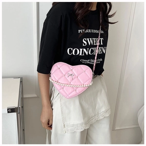 Pink heart-shaped crossbody bag with quilted pattern, white pearls, and silver chain