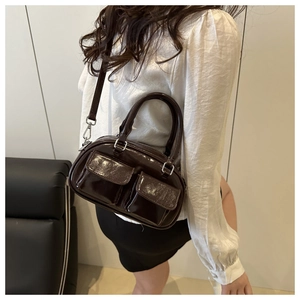 Detail of dark brown glossy patent leather tote bag with two front flap pockets