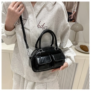Close-up of black glossy underarm bag with silver hardware and double front pockets