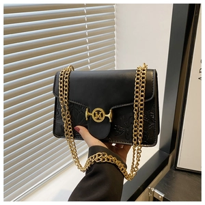 Détail du sac bandoulière noir avec motif floral gaufré et boucle métallique dorée lettre M